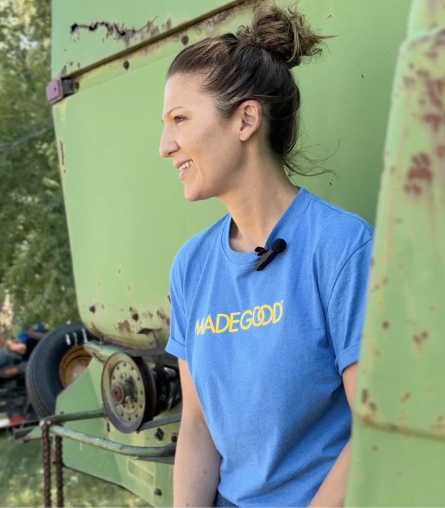 An image of Salma Fotovat, a founder of MadeGood, wearing a blue and yellow MadeGood t-shirt in a profile angle.