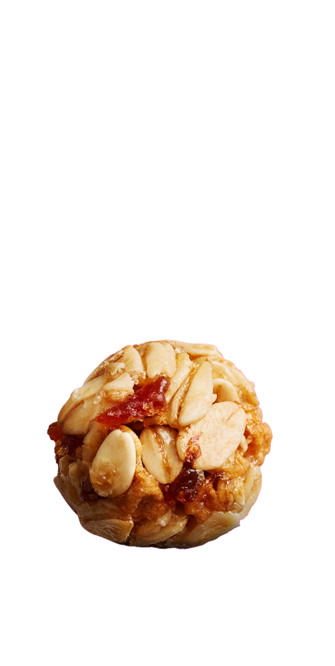 An unwrapped granola bite showing texture of oat and dried fruit ingredients